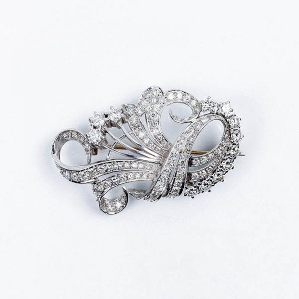 Elegante broche-alfiler vintage en oro blanco, con motivo de ramo vegetal en bandas onduladas con blancos diamantes