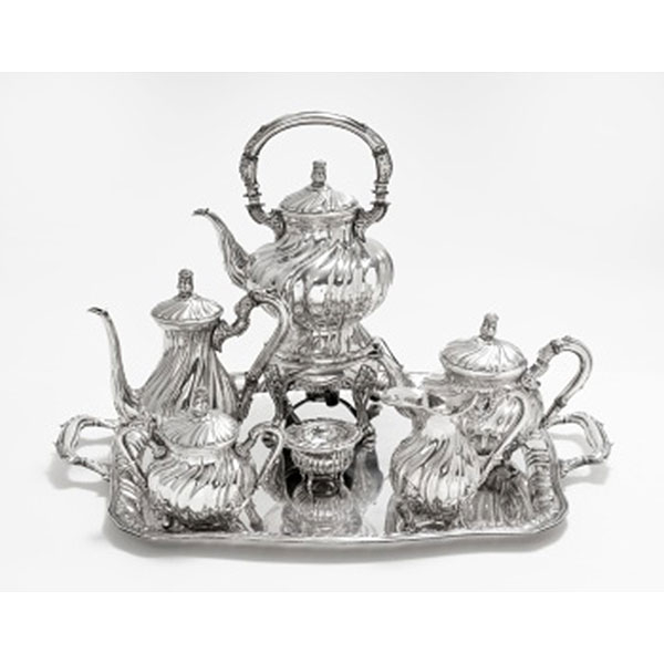Juego de café y bandeja en plata con decoración vegetal, gallones y tapa rematando en bellota, compuesto por; samovar, cafetera, tetera, lechera, azucarero y colador. Estilo Luis XVI. Marcas de platero. S. XX