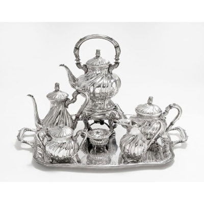 Juego de café y bandeja en plata con decoración vegetal, gallones y tapa rematando en bellota, compuesto por; samovar, cafetera, tetera, lechera, azucarero y colador. Estilo Luis XVI. Marcas de platero. S. XX