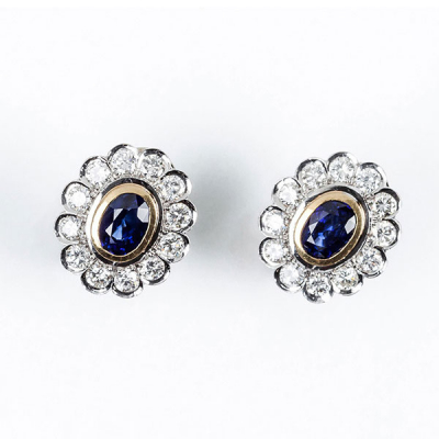 Pendientes en oro amarillo 18 K, con un zafiro fino, azul, oval y orla de limpios y blancos diamantes 