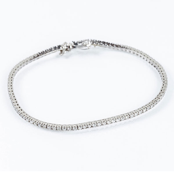 Pulsera 'rivière' en oro blanco con frente en fila de limpios y blancos diamantes talla brillante, en garras