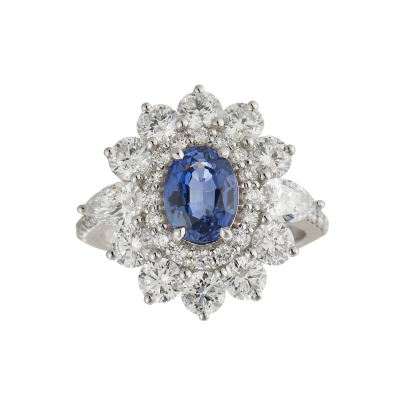 Sortija rosetón en oro blanco con zafiro azul talla oval y doble orla y brazos de diamantes tallas brillante y perilla.