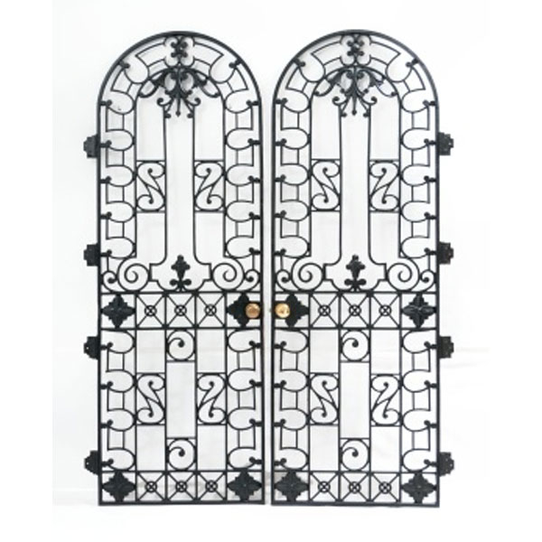 Pareja de puertas en hierro en forma de capilla con decoración geométrica, vegetal y flores con tiradores en metal.   Época: Mediados S. XX