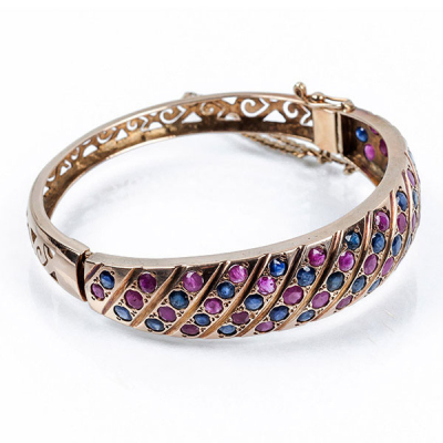 Brazalete esclavo vintage en montura de oro rosa, decorado en bandas diagonales de zafiros y rubíes circulares, alternos.