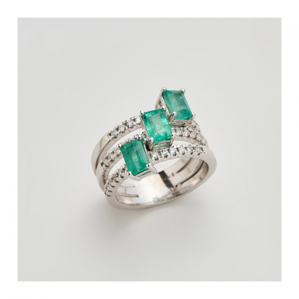 Sortija en oro blanco formada por tres aros de diamantes talla brillante y tres esmeraldas rectangulares engastadas en garras.
