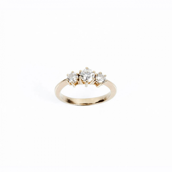 Anillo tresillo en oro amarillo 18 K, con un limpio y blanco diamante, talla brillante, flanqueado de otros dos a menor altura, en garras