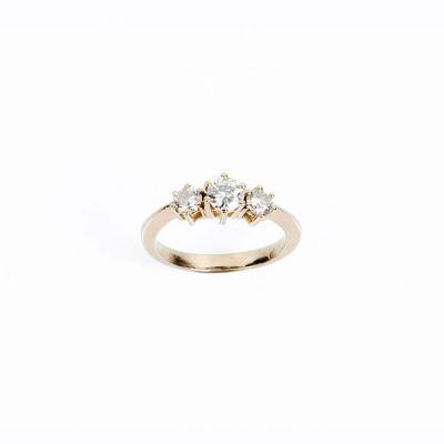 Anillo tresillo en oro amarillo 18 K, con un limpio y blanco diamante, talla brillante, flanqueado de otros dos a menor altura, en garras