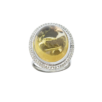 Sortija en oro blanco con cabujón oval de símil de citrino de 22 x 17 mm. orlado por diamantes talla brillante.