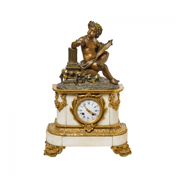 Reloj de sobremesa francés estilo Luis XVI en mármol blanco y bronce dorado, fles. del s. XIX. Caja coronada por alegoría a la escritura en bronce patinado.