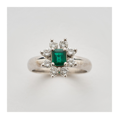 Sortija rosetón en oro blanco con esmeralda talla octogonal orlada por diamantes talla brillante.