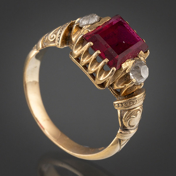 Anillo en oro amarillo de 18 kt con espinela orlada por dos brillantes.