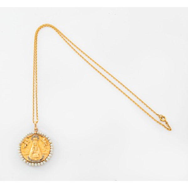 Cadena y medalla en oro amarillo representando "Virgen de Begoña" con diamantes rosas y orla de perlas.
