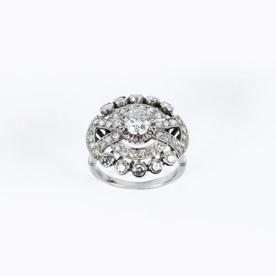 Bella sortija vintage en platino, formando un roset&oacute;n con diamante natural central, talla brillante, en garras de ilusi&oacute;n 
