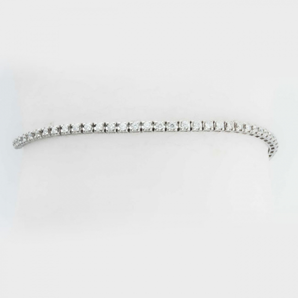 Bonita pulsera riviere en montura de oro blanco, con fila articulada de limpios y blancos diamantes, talla brillante, montados en garritasl (70 bts: 1.80 ct aprox.