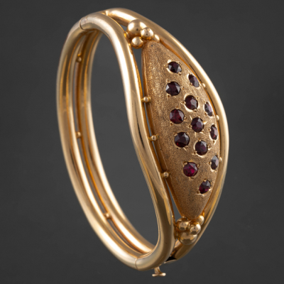 Pulsera r&iacute;gida en oro amarillo de 18 kt con granates.