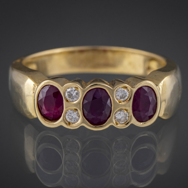 Anillo en oro amarillo de 18kt con 3 rubíes y cuatro brillantes.