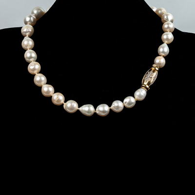 Collar-chocker formado por 29 bellas perlas australianas, barrocas, de grueso oriente, en suave disminución de 15.2 a 11.3 mm, con sólido cierre oval en oro amarillo decorado con motivo en estrella con limpios y blancos diamantes, talla brillante sobre vistas grafiladas de oro blanco