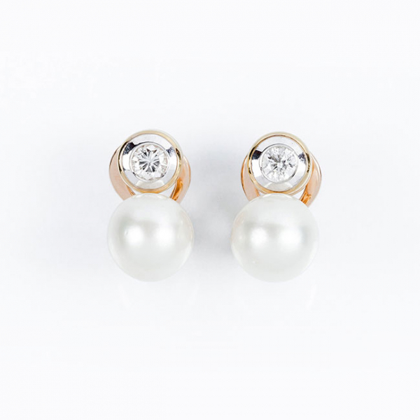 Pendientes 'tú y yo' en sólida montura de oro amarillo con un limpio y blanco diamante, talla brillante, en chatón con boquilla de oro blanco y una bella perla australiana de 11,3 mm.