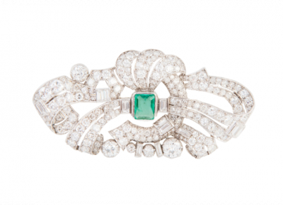 Broche de brillantes y diamantes talla baguette con diseño de cintas entrelazadas y esmeralda central.   En oro blanco de 18 K.