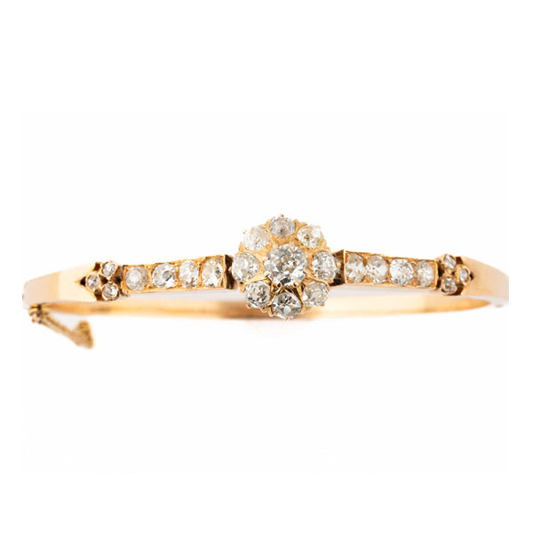 Brazalete esclavo antiguo en oro rosa 18 K, con rosetón de limpios y blancos diamantes, talla brillante 'cushion' antigua, en garras, flanqueado por filas de diamantes y motivo de diamantitos