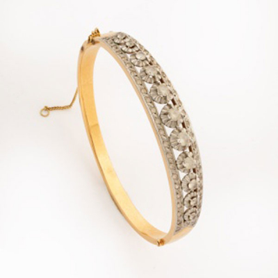 Pulsera esclava en oro amarillo y oro blanco representando flores con fila de zafiros blancos