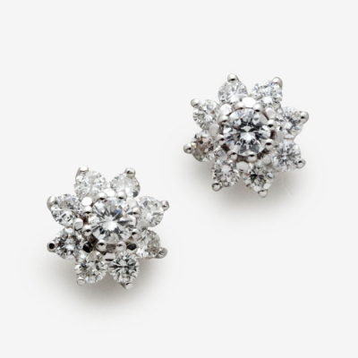 Pendientes en oro blanco en forma de flor con diamante talla brillante central y orla de diamantes talla brillante  