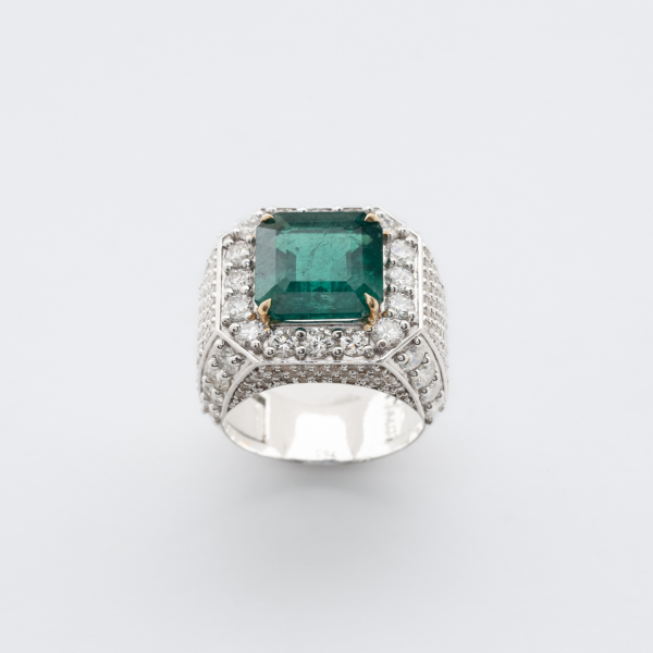 Sortija diseño sello en oro blanco con esmeralda central talla octogonal y cuerpo cuajado de diamantes talla brillante.