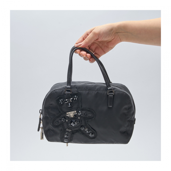 PRADA. Bolso de mano modelo «Evening Bear» en nylon, piel nergra y pedrería con cierre de cremallera y candado con dos llaves.