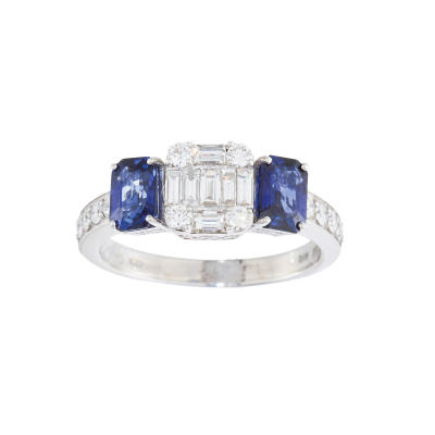 Sortija en oro blanco con centro de diamantes tallas brillante y baguette custodiado por zafiros azules talla esmeralda y brazos de diamantes talla brillante.