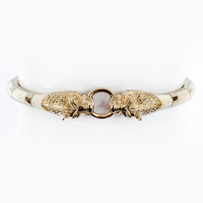 Pulsera esclava vintage de excelente factura, en sólida montura de oro amarillo con incrustaciones de dentina natural. Motivo de cabezas de felino enfrentadas.
