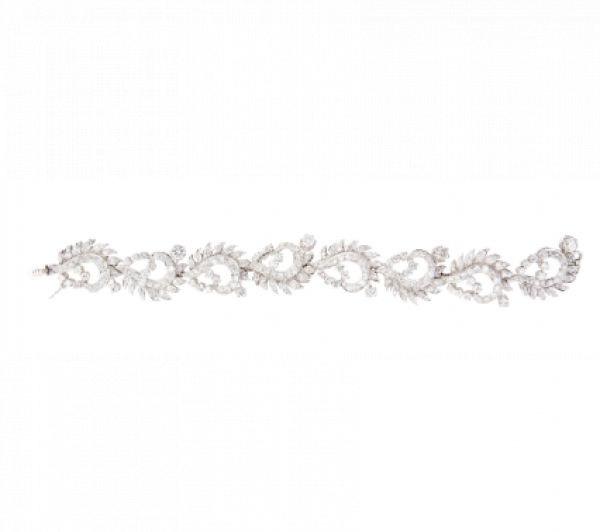 Brazalete años 50 con ocho centros de cintas onduladas decoradas con hojitas de brillantes, y brillantes en garras de mayor tamaño.   En oro blanco de 18K.
