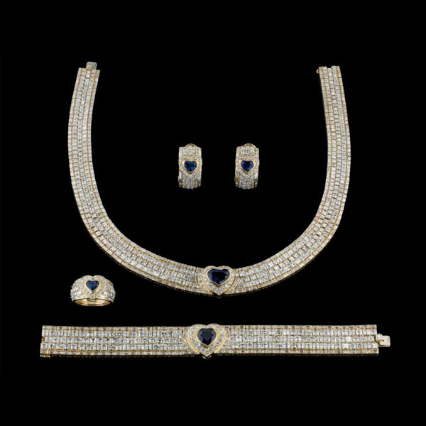 Extraordinario juego formado por: collar, pulsera, pendientes y anillo de oro amarillo de 18 K. con zafiros azules