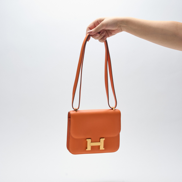 HERMÈS. Bolso modelo «Constance 18» en piel Swift de color Orange H con cierre de click imantado.