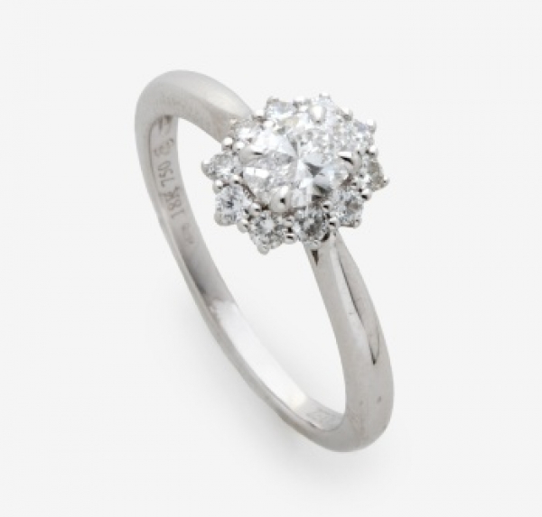 Sortija con diamante talla oval central y orla alrededor de 10 diamantes talla brillante con un peso total 0,55 cts. aprox.