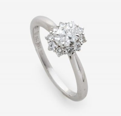 Sortija con diamante talla oval central y orla alrededor de 10 diamantes talla brillante con un peso total 0,55 cts. aprox.
