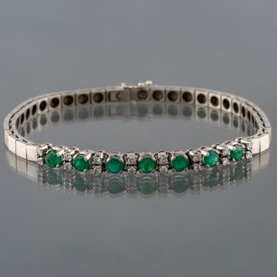 Pulsera articulada en oro blanco de 18kt con diamantes talla brillante pareados y esmeraldas talla redonda.