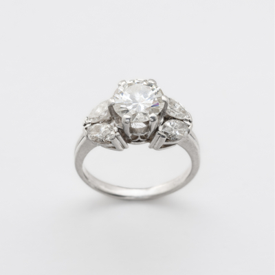Sortija en oro blanco con diamante central talla brillante custodiado por parejas de diamante talla marquise. 