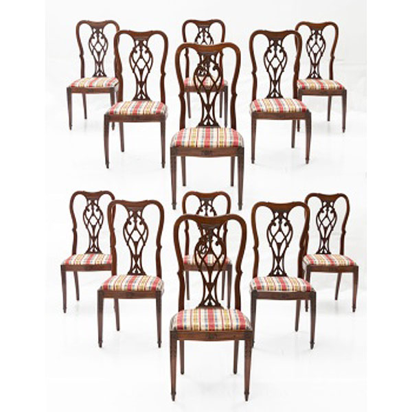 Conjunto de 12 sillas de comedor en madera de caoba tallada con decoración vegetal y asiento tapizado a cuadros. Estilo Victoriano. Época: Pp. S. XX