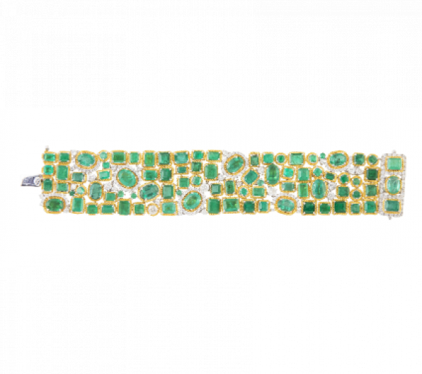 Brazalete ancho articulado cuajado de esmeraldas de distintas tallas. En oro bicolor de 18K. 