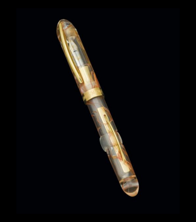 Estilográfica marca VISCONTI, modelo Millenium, realizada en celuloide transparente con veteado naranja.