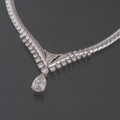 Gargantilla en oro blanco de 18 kt con colgante de diamante talla pera orlado de brillantes.