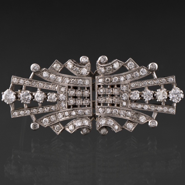 Broche de doble clip en oro banco cuajado de brillantes.