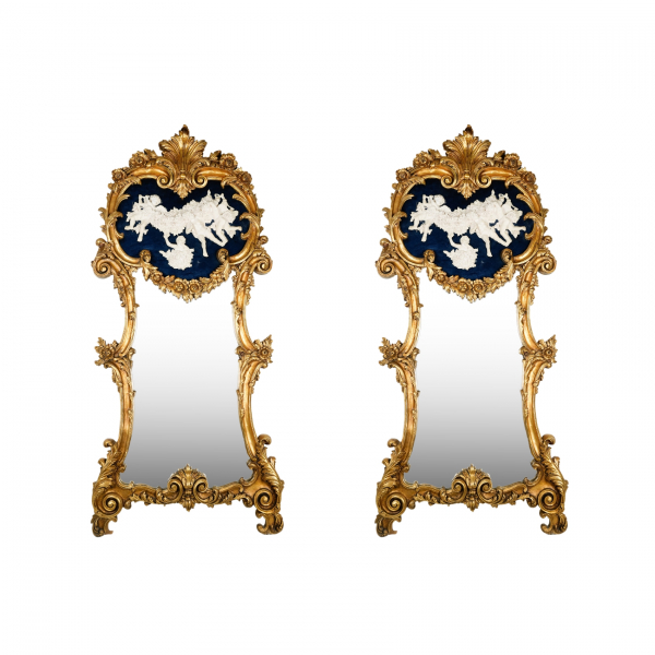 Pareja de espejos &laquo;Trumeau&raquo; en pasta de madera dorada con copete decorado por querubines en relieve 