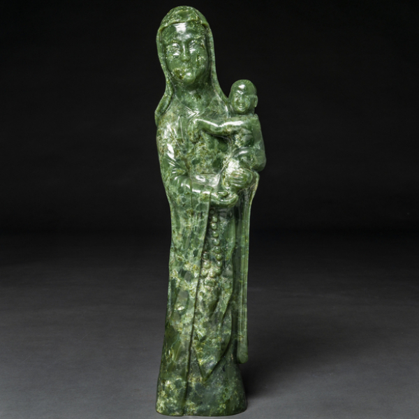 "Guanyin con niño" Figura de bulto redondo en jade verde color espinaca. Trabajo Chino del siglo XX.