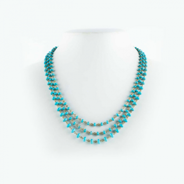 Delicada cadena extralarga en oro amarillo 18 K, con cuentas &#039;donut&#039; de turquesitas naturales en ligera disminución.