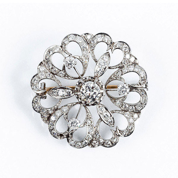 Alfiler vintage en oro blanco con motivo de rosetón calado, cuajado de limpios y blancos diamantes, talla brillante, y centro en garras de ilusión
