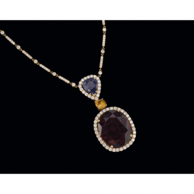 Importante collar de oro amarillo de 18 K. con gran turmalina rubelita talla oval de 33 cts., y zafiros.