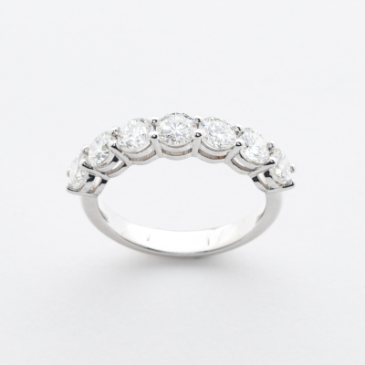 Sortija media alianza en oro blanco con diamantes talla brillante engastados en garras.  