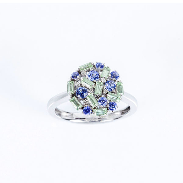 Sortija en oro blanco 18 K, con motivo circular cuajado de piedras finas, (amatistas verdes y tanzanitas), salteadas con diamantitos