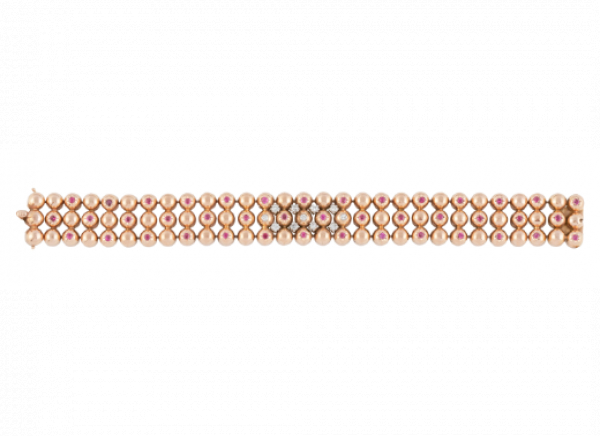 Brazalete años 40 de tres bandas de semiesferas, decoradas con rubíes y con ocho brillantes en el frente.   En montura de oro rosa 18K.